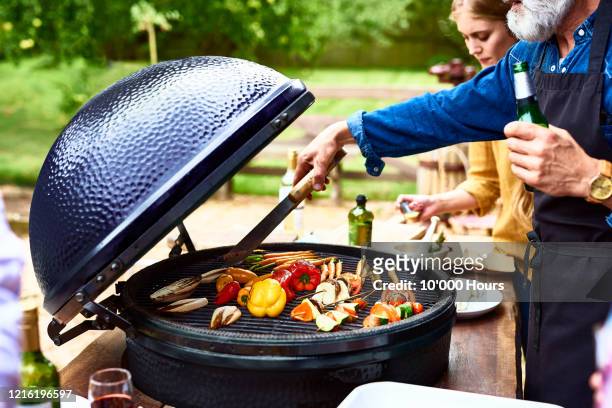 mature man cooking vegetables on barbecue - grilled vegetables stock pictures, royalty-free photos & images