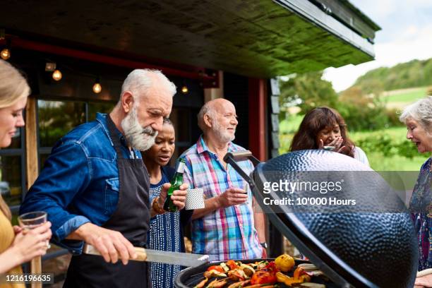 mature man grilling vegetables at garden party - barbecue social gathering stock pictures, royalty-free photos & images