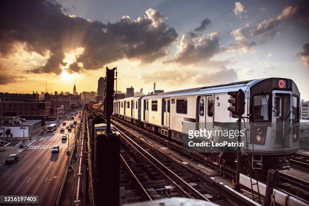 elevated subway train und new york city skyline - brooklyn new york stock-fotos und bilder