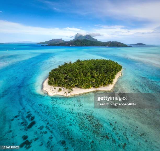 beautiful aerial view of island among blue sea and mt.otemanu at bora bora island , french polynesia - bora bora stock pictures, royalty-free photos & images