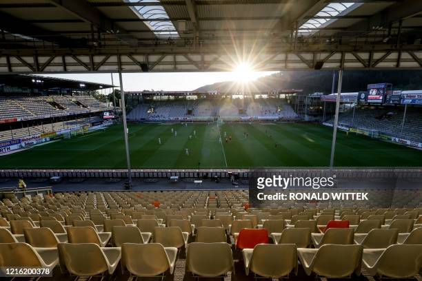 Players vie for the ball in front of empty stands as the sun sets during the German first division Bundesliga football match SC Freiburg v Bayer 04...