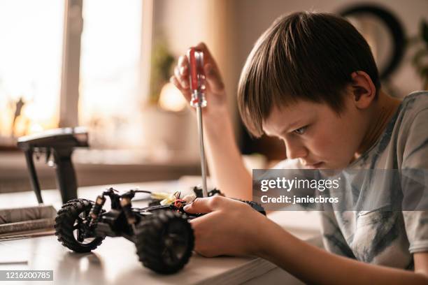 kind junge repariert ein ferngesteuertes autospielzeug - boy with car stock-fotos und bilder