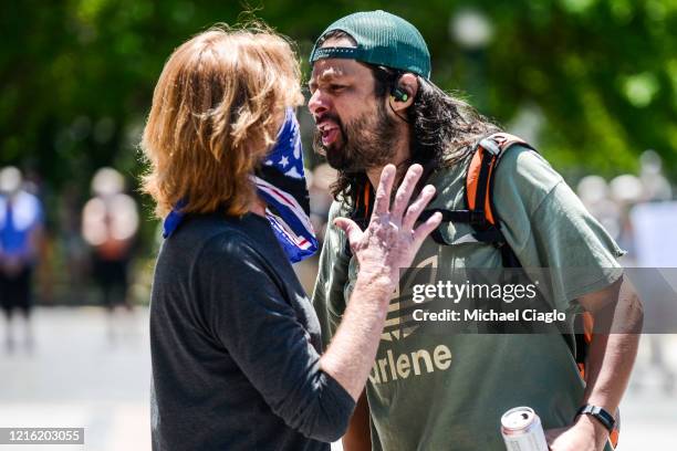 Man yells at a counter-protester, left, as people hold a rally to protest of the death of George Floyd on the steps of the Colorado state capitol on...