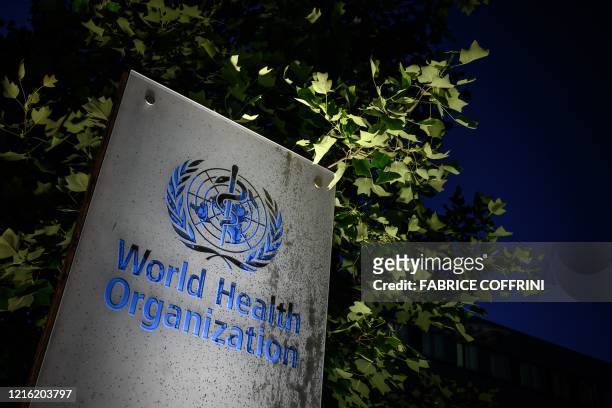 Photo taken in the late hours of May 29, 2020 shows a sign of the World Health Organization at their headquarters in Geneva amid the COVID-19...