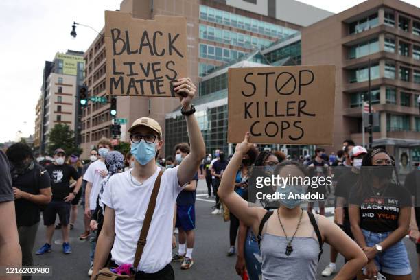 People hold banners reading "Black Lives Matter - Stop Killer Cops", as crowds gather to protest after the death of George Floyd in Washington D.C....