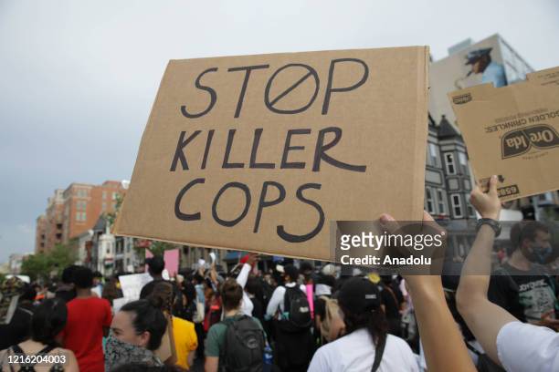 Person holds a banner reading "Stop Killer Cops", as crowds gather to protest after the death of George Floyd in Washington D.C. United States on May...