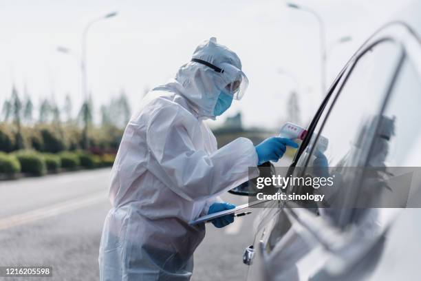 the staff is taking the driver temperature during covid-19 - pandemia fotografías e imágenes de stock