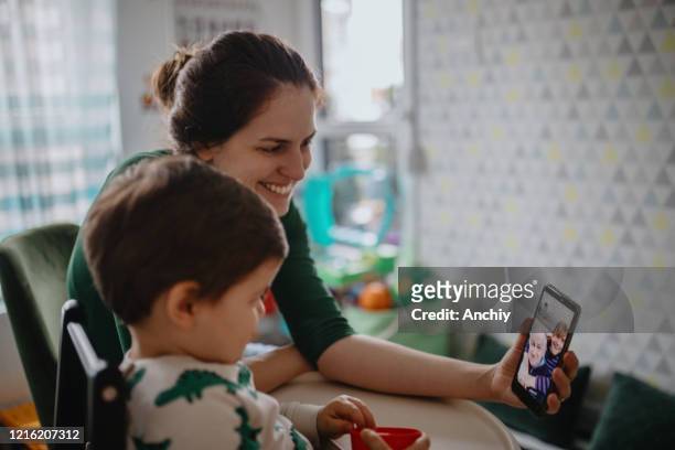 grootouders in quarantaine thuis hebbend videovraag met kleinzoon en dochter - mother daughter webcam stockfoto's en -beelden