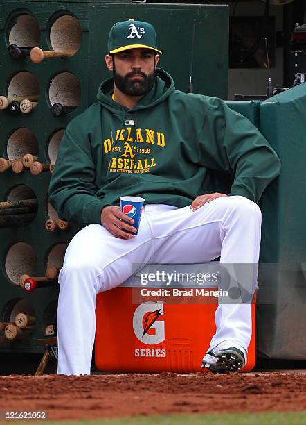 Conor Jackson of the Oakland Athletics watches from the dugout and sits on a Gatorade cooler during the game against the Toronto Blue Jays at O.co...