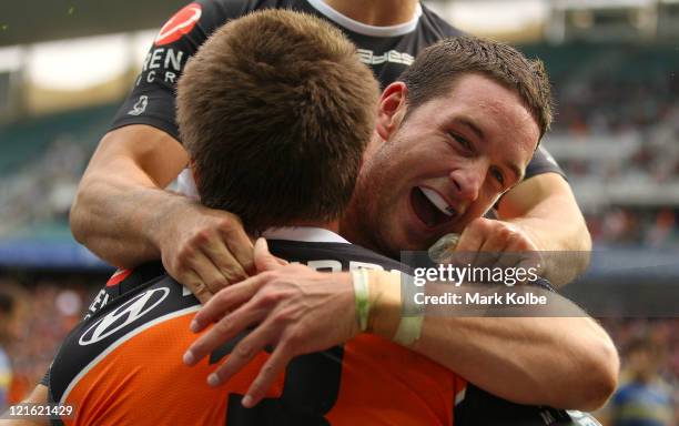 Tim Moltzen of the Tigers congratulates Blake Ayshford of the Tigers after he scored a try during the round 24 NRL match between the Wests Tigers and...