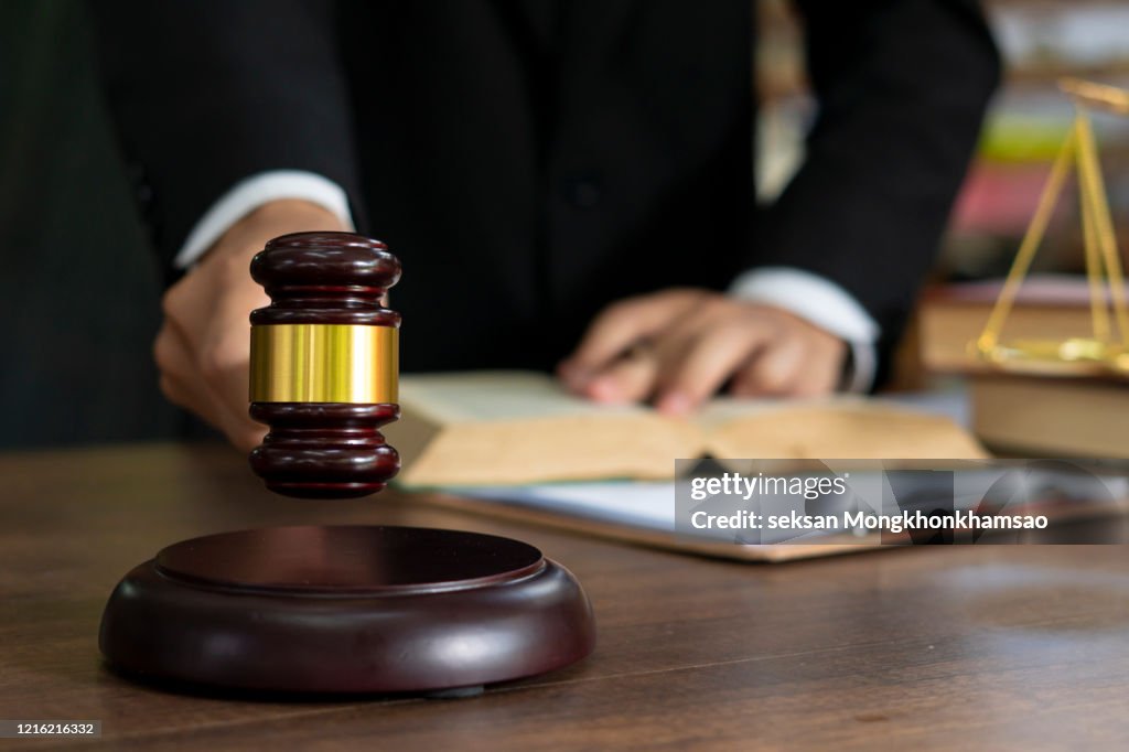 Close up lawyer businessman working or reading lawbook in office workplace for consultant lawyer concept.