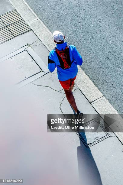 Runner on an otherwise empty street that would usually be full of people traveling to work in the City of London financial district on March 31, 2020...