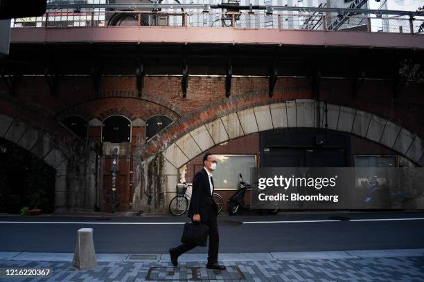 Pedestrian wearing a protective mask walks near Yurakucho station of Tokyo, Japan, Friday on May 29, 2020. Small clusters of coronavirus cases have...