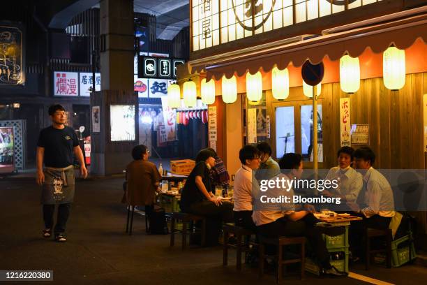 Customers dine at an izakaya bar at night in the Yurakucho district of Tokyo, Japan, Friday on May 29, 2020. Small clusters of coronavirus cases have...