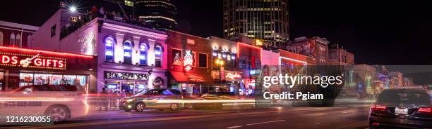 people walk along broadway in nashville tennessee usa - tennessee music stock pictures, royalty-free photos & images