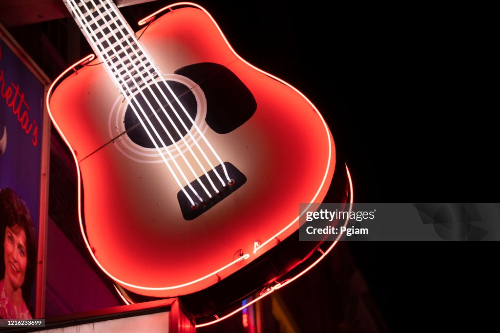 Neon guitar storefront sign at night in Nashville Tennessee USA