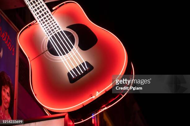 neon guitar storefront sign at night in nashville tennessee usa - country and western music stock pictures, royalty-free photos & images