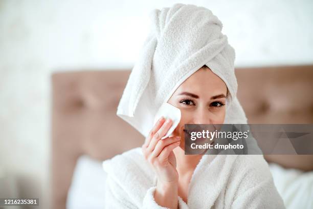 beautiful woman portrait cleaning her face with a cotton bud - removing make up stock pictures, royalty-free photos & images