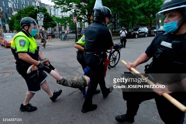 Police officers carry a detained protester after clashes outside the District Four Police station during a Black Lives Matter protest against police...