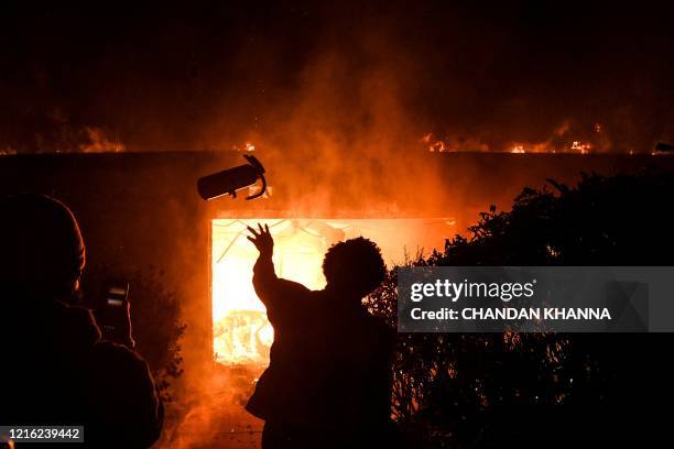 Protester throws a fire extinguisher in a burning building during a demonstration in Minneapolis, Minnesota, on May 29 over the death of George...