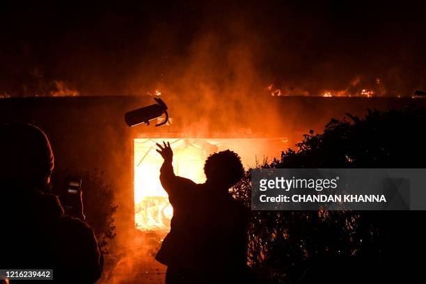 Protester throws a fire extinguisher in a burning building during a demonstration in Minneapolis, Minnesota, on May 29 over the death of George...