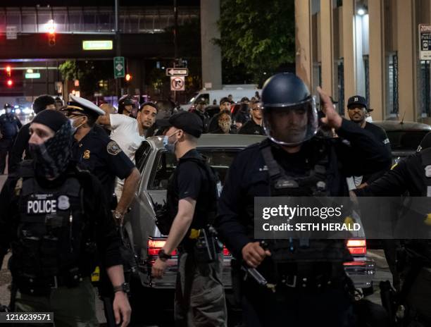 Detroit riot police officers are present during a protest in the city of Detroit, Michigan, on May 29 over the death of George Floyd, a black man who...