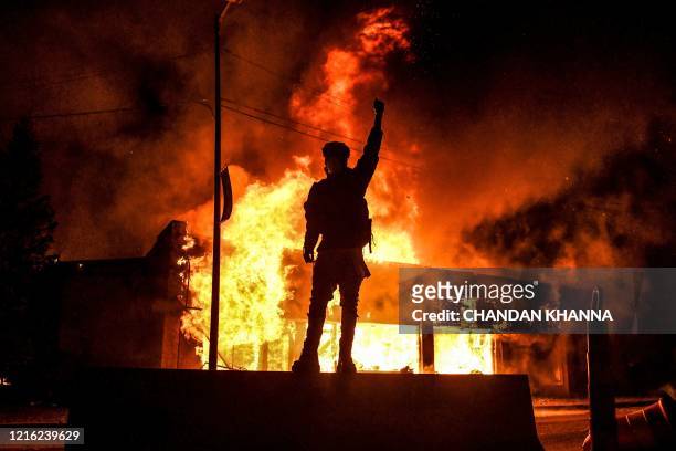 Protester reacts standing in front of a burning building set on fire during a demonstration in Minneapolis, Minnesota, on May 29 over the death of...