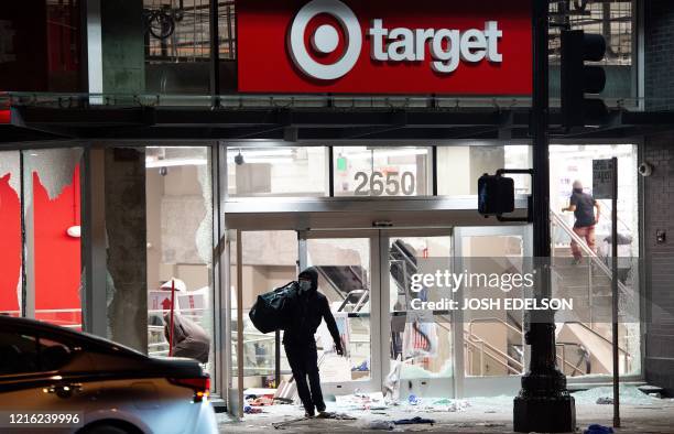 Looter rob a Target store as protesters face off against police in Oakland California on May 30 over the death of George Floyd, a black man who died...