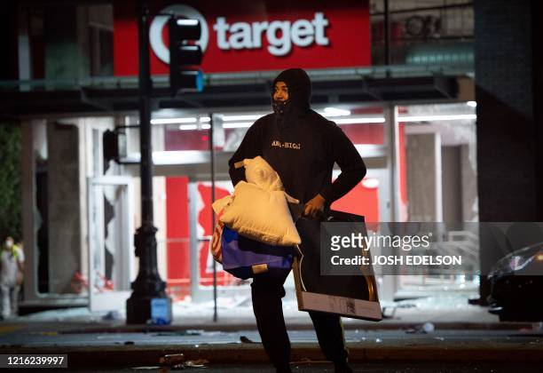 Looter rob a Target store as protesters face off against police in Oakland California on May 30 over the death of George Floyd, a black man who died...