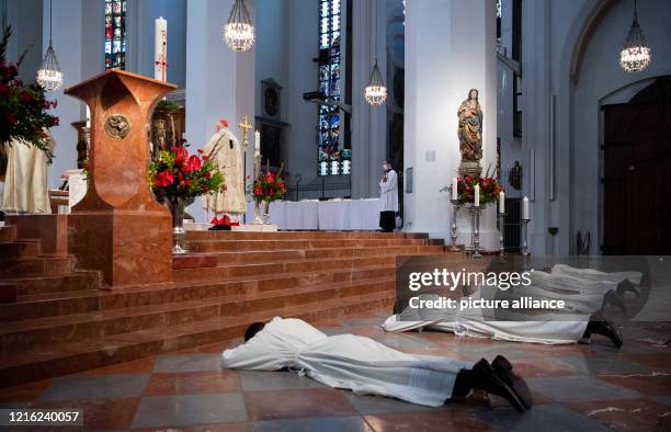 May 2020, Bavaria, Munich: Five candidates for priesthood lie on the floor in the Liebfrauendom before their ordination as deacons during a service....