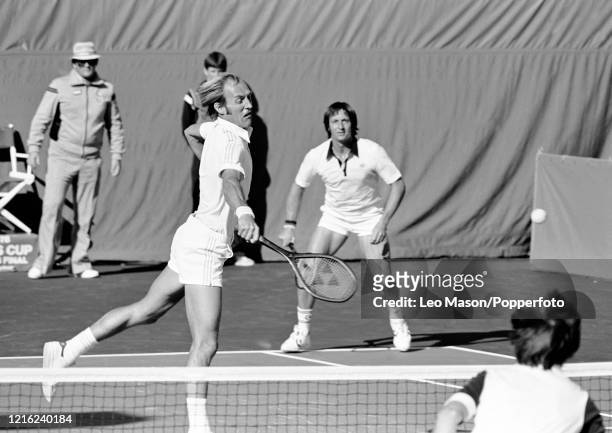 Stan Smith of the United States returns the ball as doubles partner Bob Lutz looks on during the 3rd rubber against David Lloyd of Great Britain and...