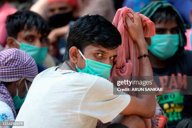 Stranded migrant labourers gather at an assembling centre to get transferred to a railway station to board on a special train to Bihar after the...