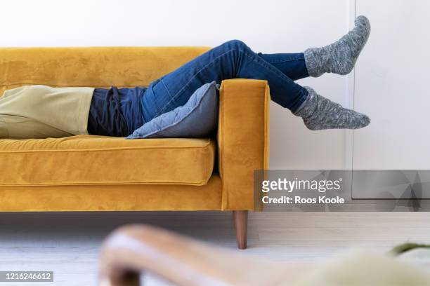legs on a couch - women lying imagens e fotografias de stock