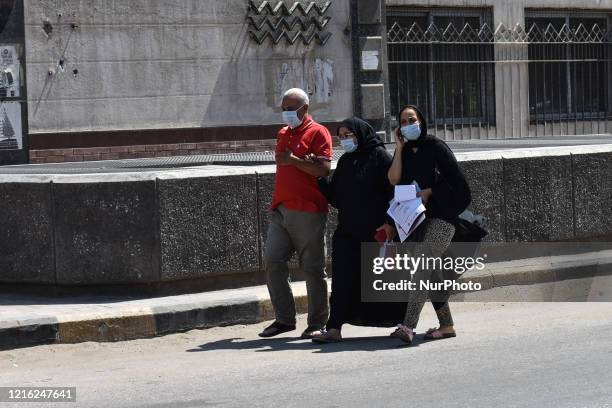 People wearing face masks while walking on a street, in Cairo, Egypt, on May 30, 2020. People in Egypt will have to wear face masks in public places...