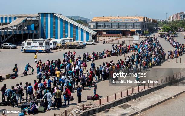 Migrant workers and their family members stand in a queue and waiting for the bus at Dharavi to go to Lokmanya tilak terminus as a special train...