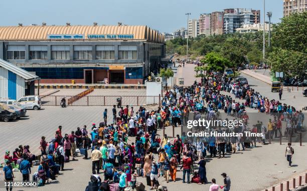 Migrant workers and their family members stand in a queue and waiting for the bus at Dharavi to go to Lokmanya tilak terminus as a special train...