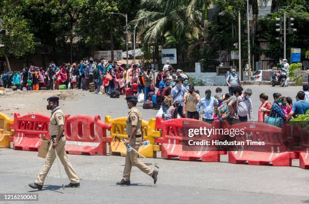 Migrant workers and their family members stand in a queue and waiting for the bus at Dharavi to go to Lokmanya tilak terminus as a special train...