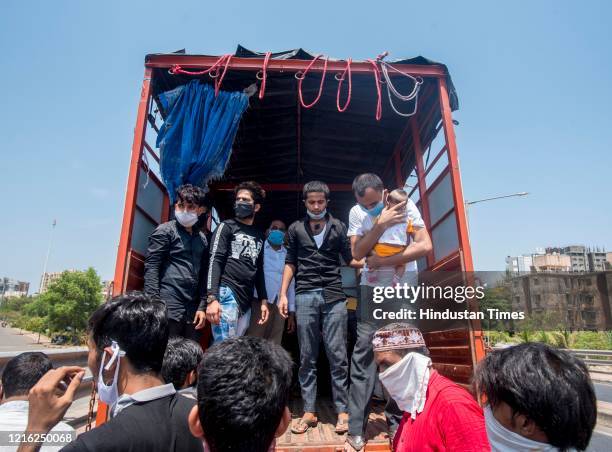 Migrant workers and their family members stand in a queue and waiting for the bus at Dharavi to go to Lokmanya tilak terminus as a special train...