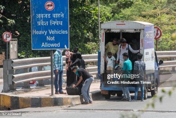 Migrant workers and their family members stand in a queue and waiting for the bus at Dharavi to go to Lokmanya tilak terminus as a special train...