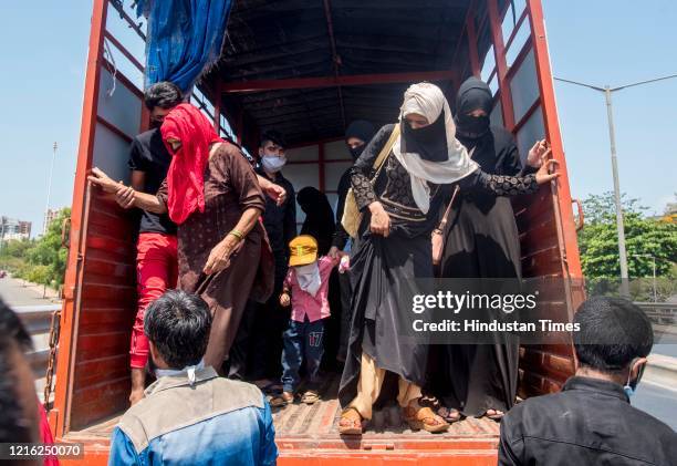 Migrant workers and their family members stand in a queue and waiting for the bus at Dharavi to go to Lokmanya tilak terminus as a special train...