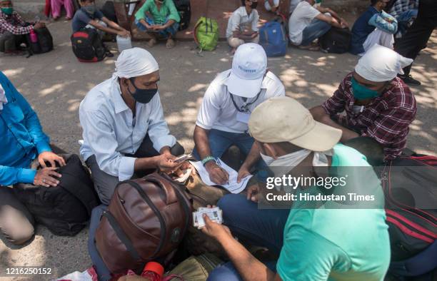 Migrant workers and their family members stand in a queue and waiting for the bus at Dharavi to go to Lokmanya tilak terminus as a special train...