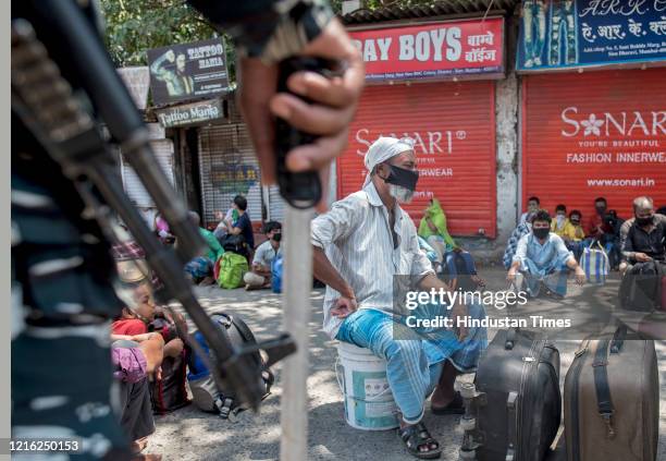 Migrant workers and their family members stand in a queue and waiting for the bus at Dharavi to go to Lokmanya tilak terminus as a special train...