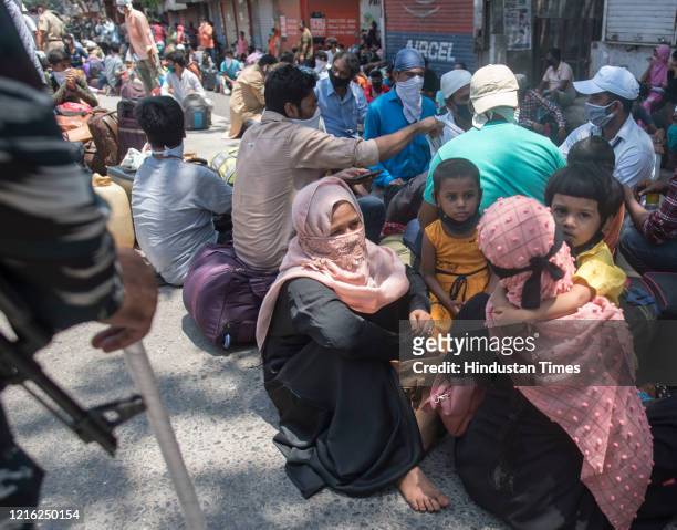 Migrant workers and their family members stand in a queue and waiting for the bus at Dharavi to go to Lokmanya tilak terminus as a special train...