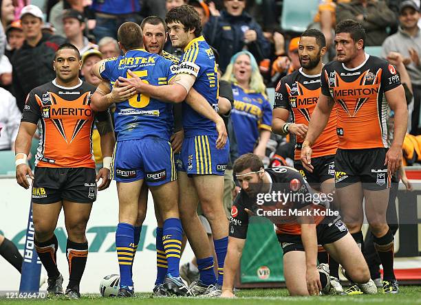 Ben Smith of the Eels is congratulated by his team mates after scoring a try during the round 24 NRL match between the Wests Tigers and the...