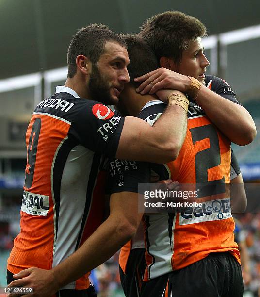 Robbie Farah, Beau Ryan and Blake Ayshford of the Tigers celebrate after a try during the round 24 NRL match between the Wests Tigers and the...