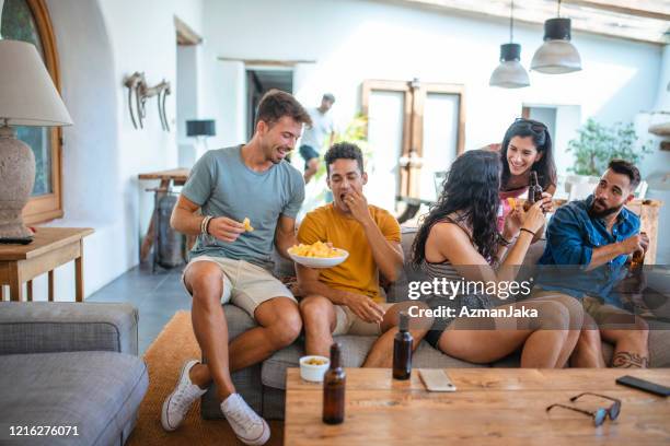 amigos disfrutando de cervezas y aperitivos en casual social gathering - patatas fritas de churrería fotografías e imágenes de stock