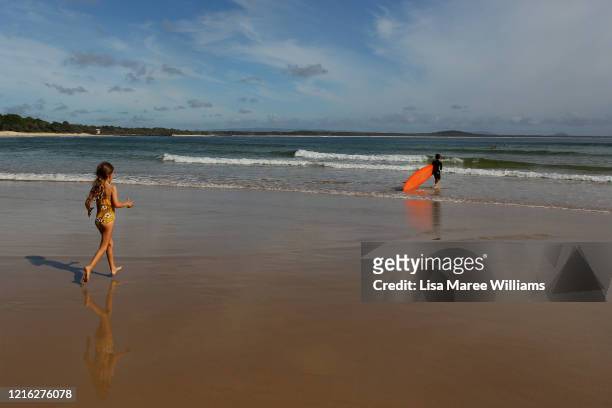 Rio Wilson and brother Elvis Wilson head out for a surf at Main Beach on March 31, 2020 in Noosa, Australia. Public gatherings are now limited to two...