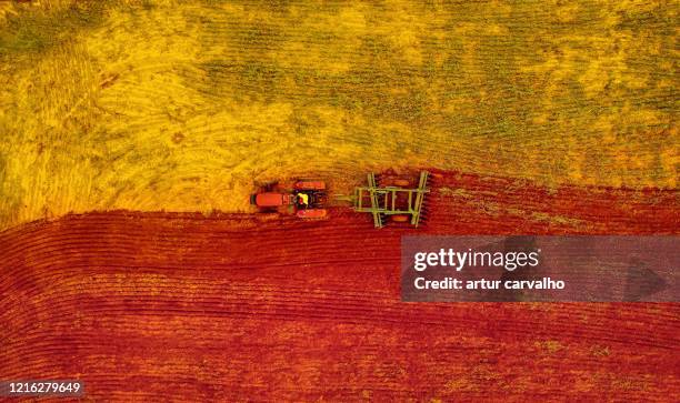 aerial view of the tractor in the field - solo vermelho - fotografias e filmes do acervo