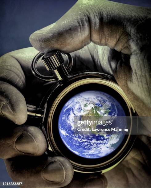 hand holding stop watch with nasa public domain earth image - time bomb 個照片及圖片檔