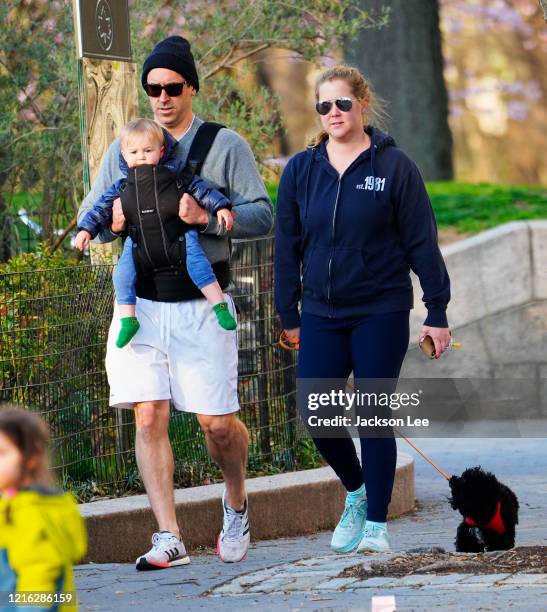 Amy Schumer and husband Chris Fischer take a walk in the park with their son Gene Fischer and the family dog on April 01, 2020 in New York City.